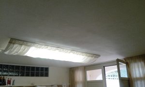 tende filtranti in tessuto ignifugo su binari a soffitto per schermatura luci al neon